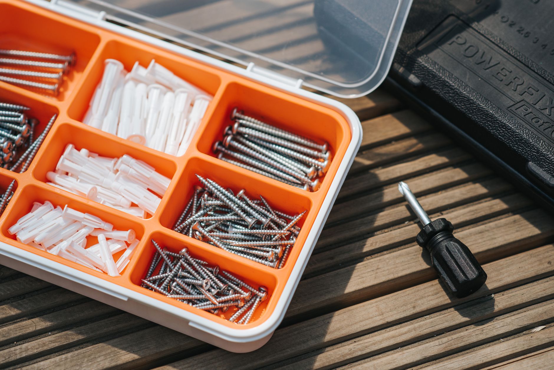 Organized beginner home tool kit with essential hand tools and safety gear arranged in a compact box.