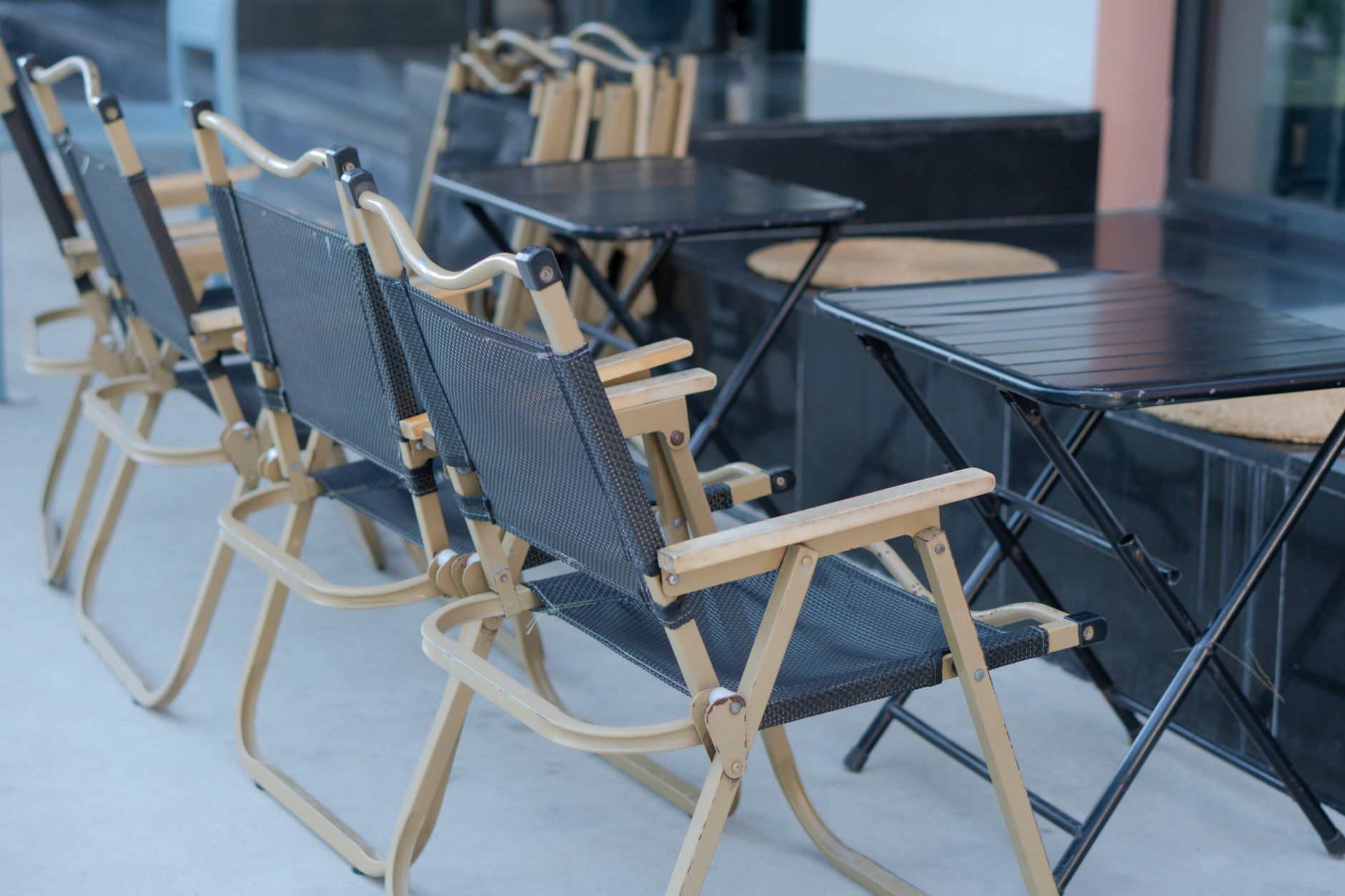 A neat arrangement of foldable chairs and tables outside, perfect for outdoor gatherings.